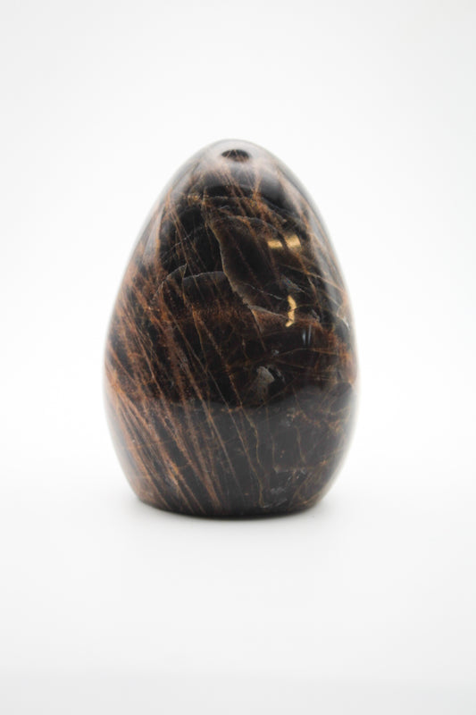 A polished free-form black moonstone with visible patterns of natural mineral inclusions.