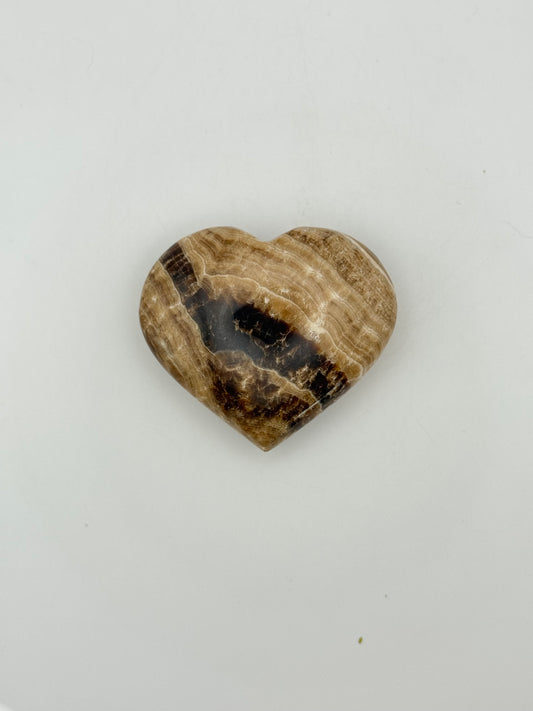 A polished chocolate calcite heart-shaped stone with a brown and white marbled pattern.