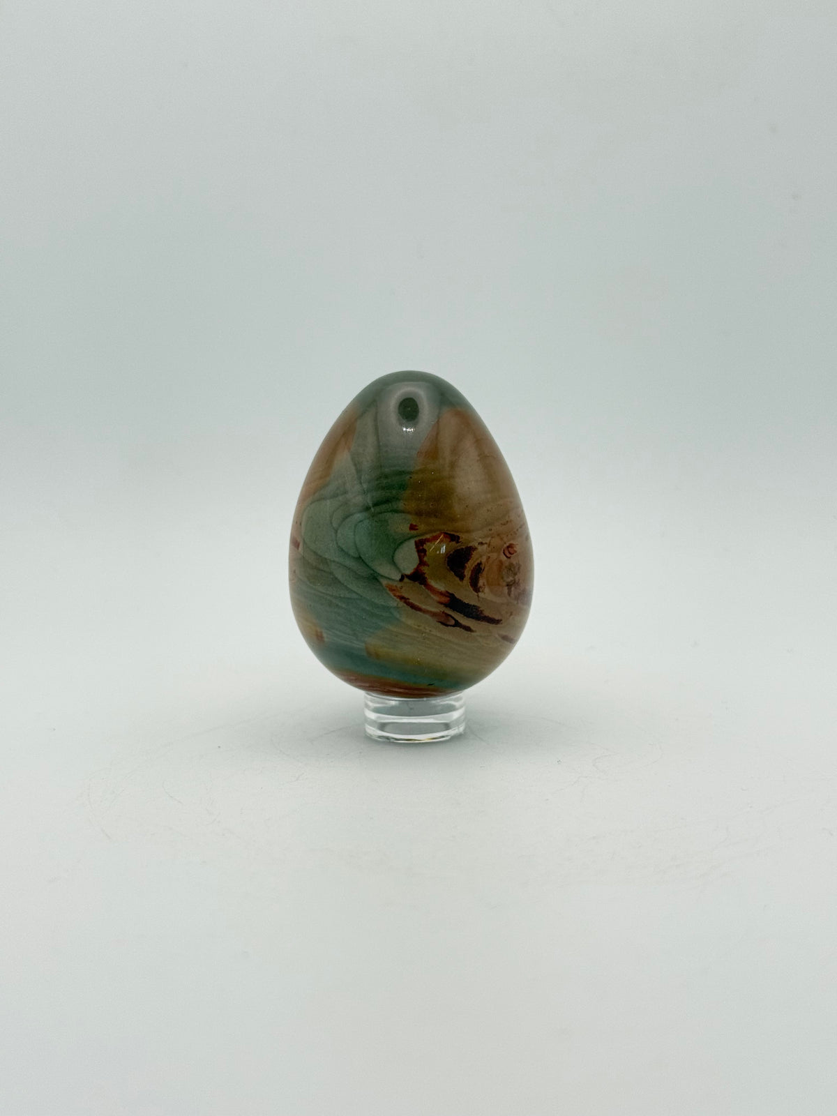 Polished polychrome jasper shaped into an egg.