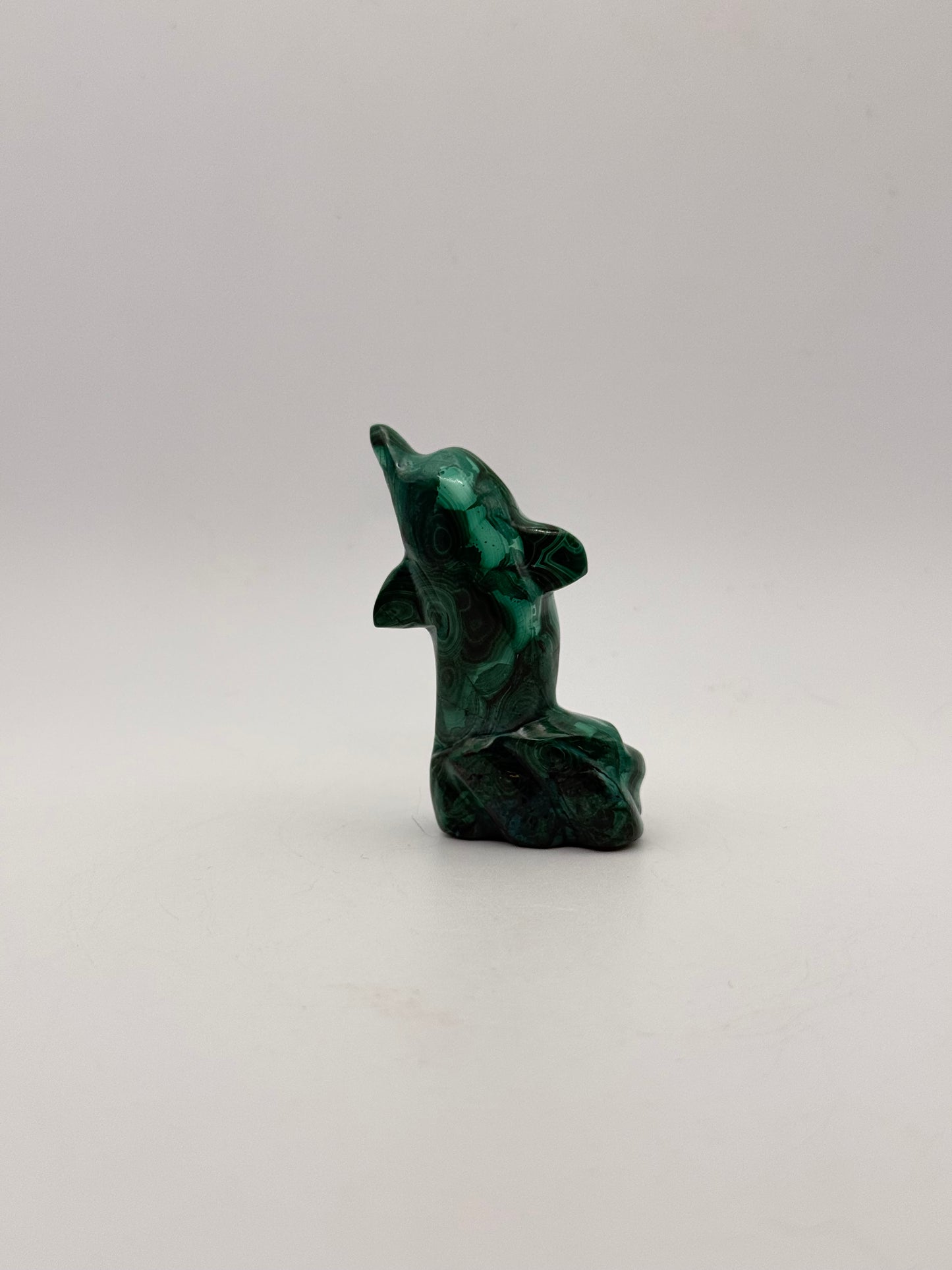 Polished malachite dolphin carving.