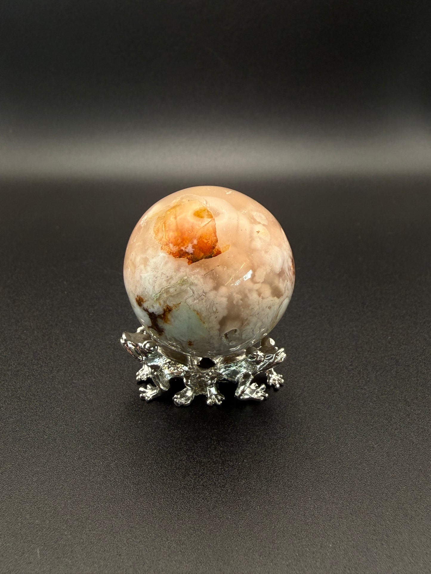 Flower agate polished crystal in the shape of a sphere.