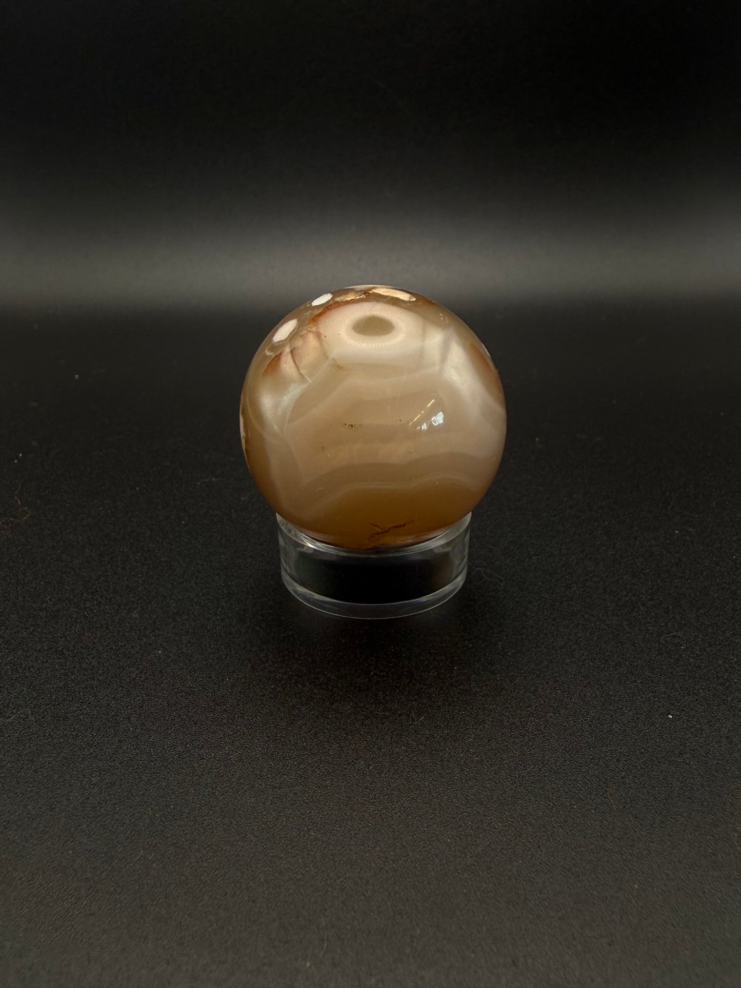 Flower agate polished crystal in the shape of a sphere.
