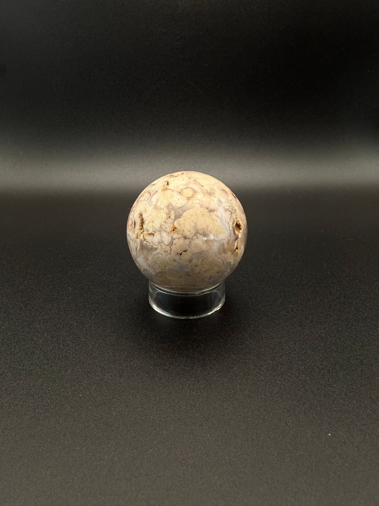 Flower agate polished crystal in the shape of a sphere.