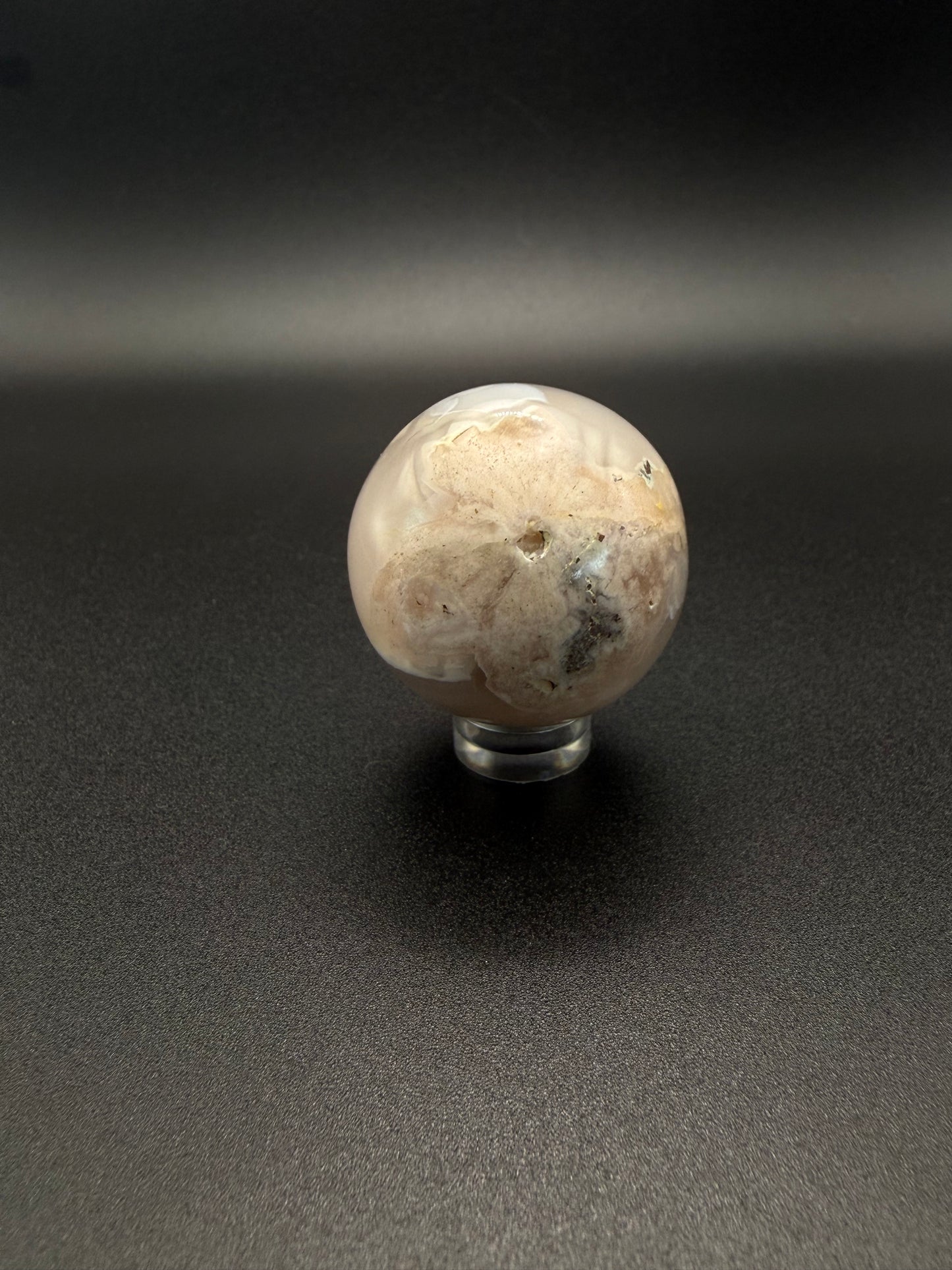 Flower agate polished crystal in the shape of a sphere.