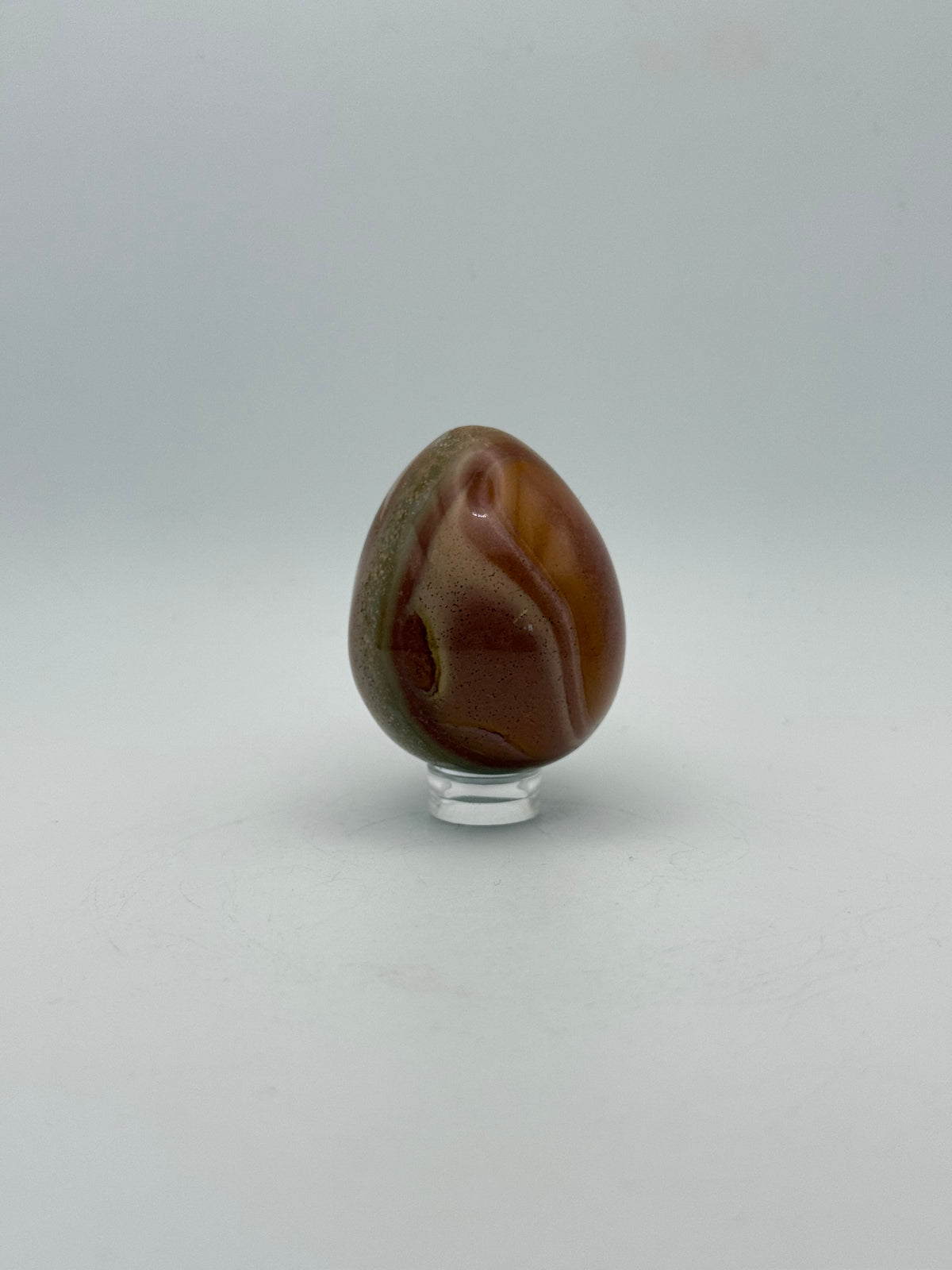 Polished polychrome jasper shaped into an egg.