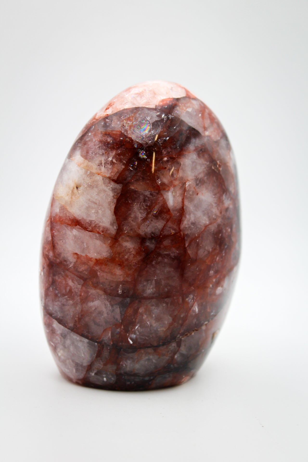 A polished red hematoid mineral specimen with a smooth surface.