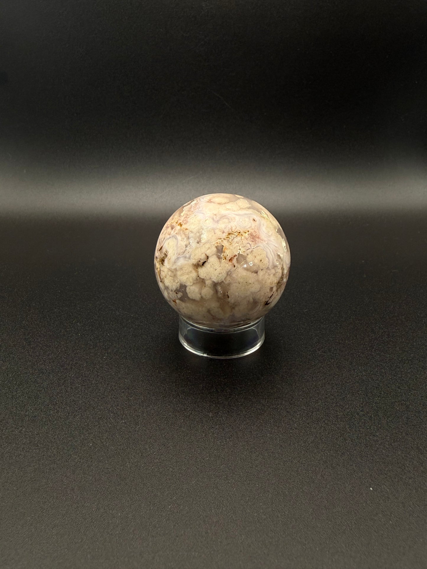 Flower agate polished crystal in the shape of a sphere.