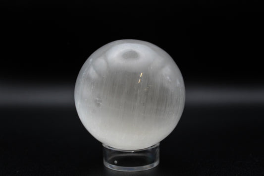 A 6cm selenite crystal sphere displayed on a black background with a clear stand.