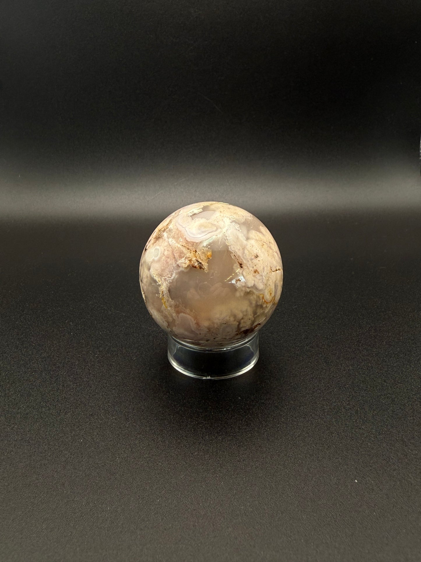 Flower agate polished crystal in the shape of a sphere.