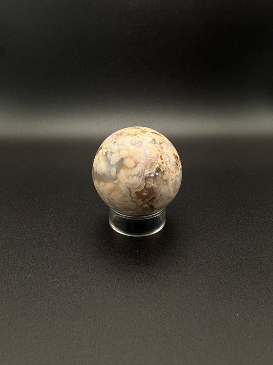 Flower agate polished crystal in the shape of a sphere.
