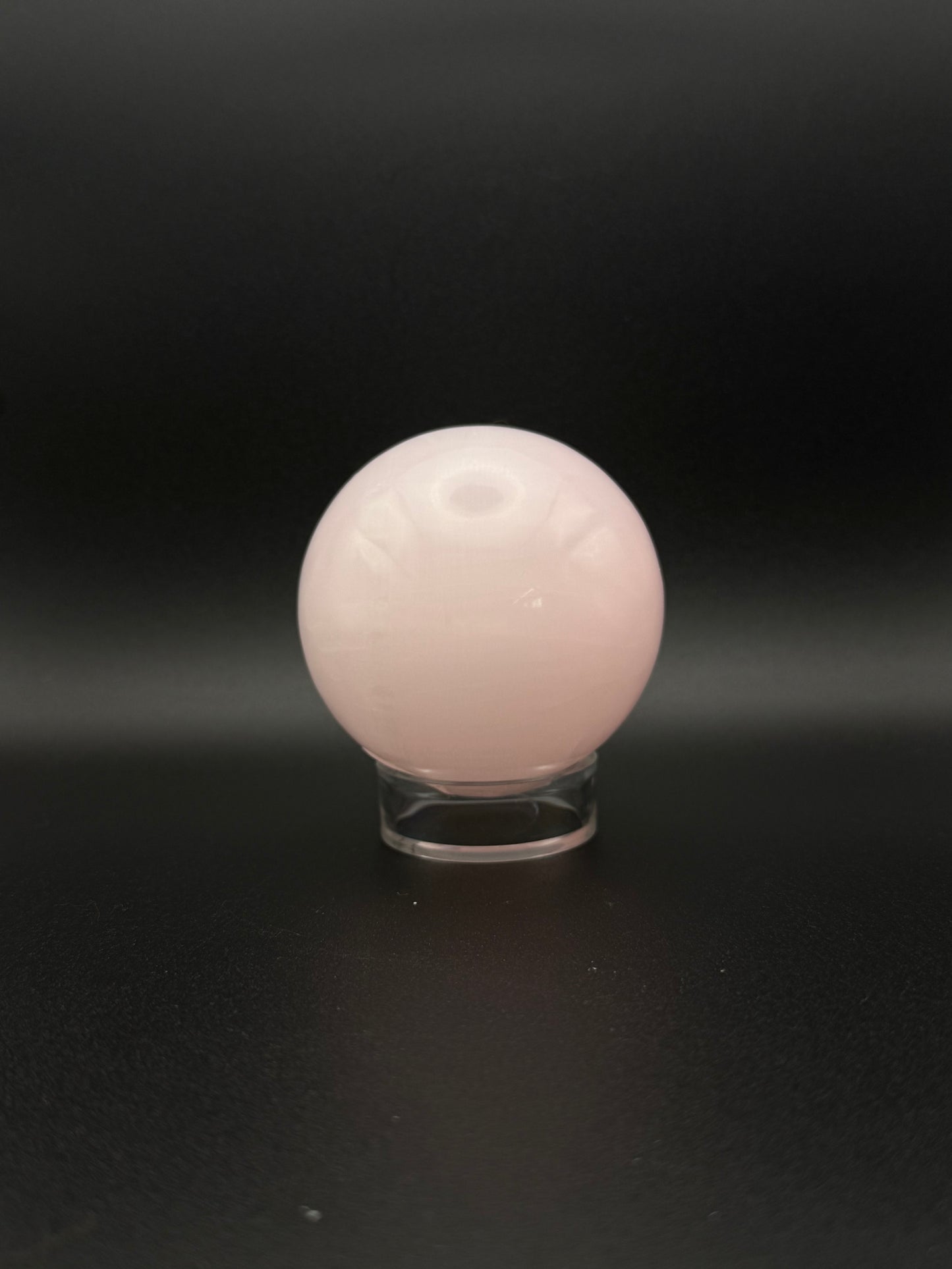 Polished pink calcite sphere. Pink calcite glows under uv light.