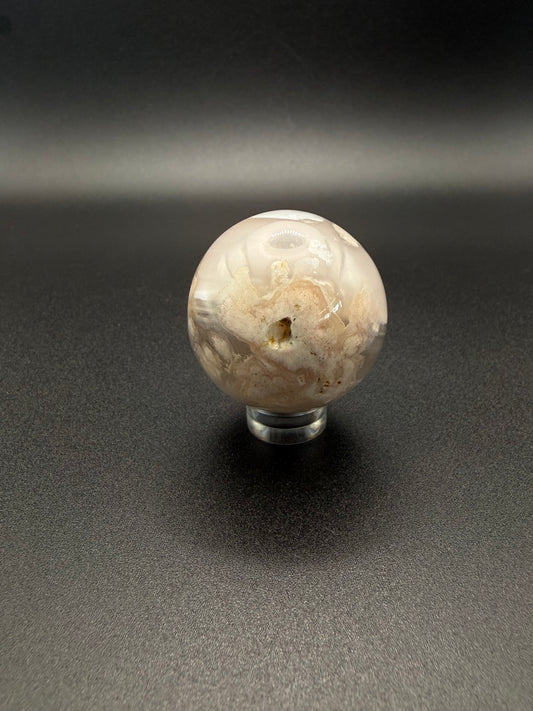 Flower agate polished crystal in the shape of a sphere.