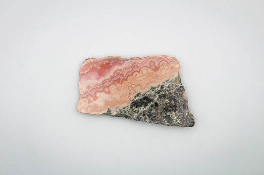 A polished rhodochrosite crystal slice.