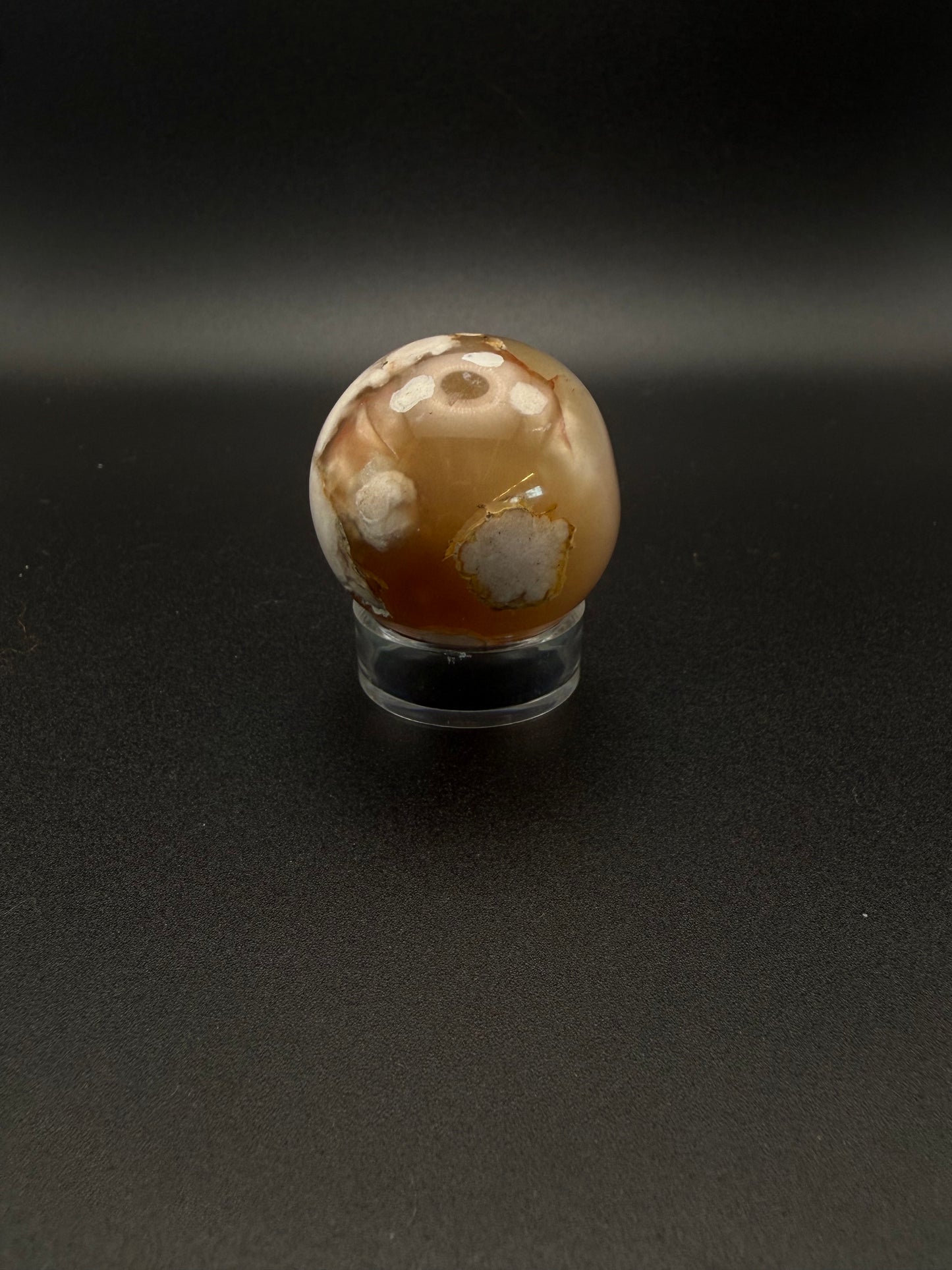 Flower agate polished crystal in the shape of a sphere.