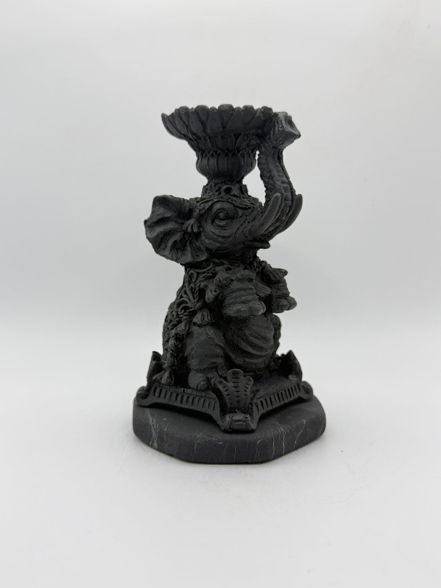 Shungite carving of an elephant that can be used as a candle holder.