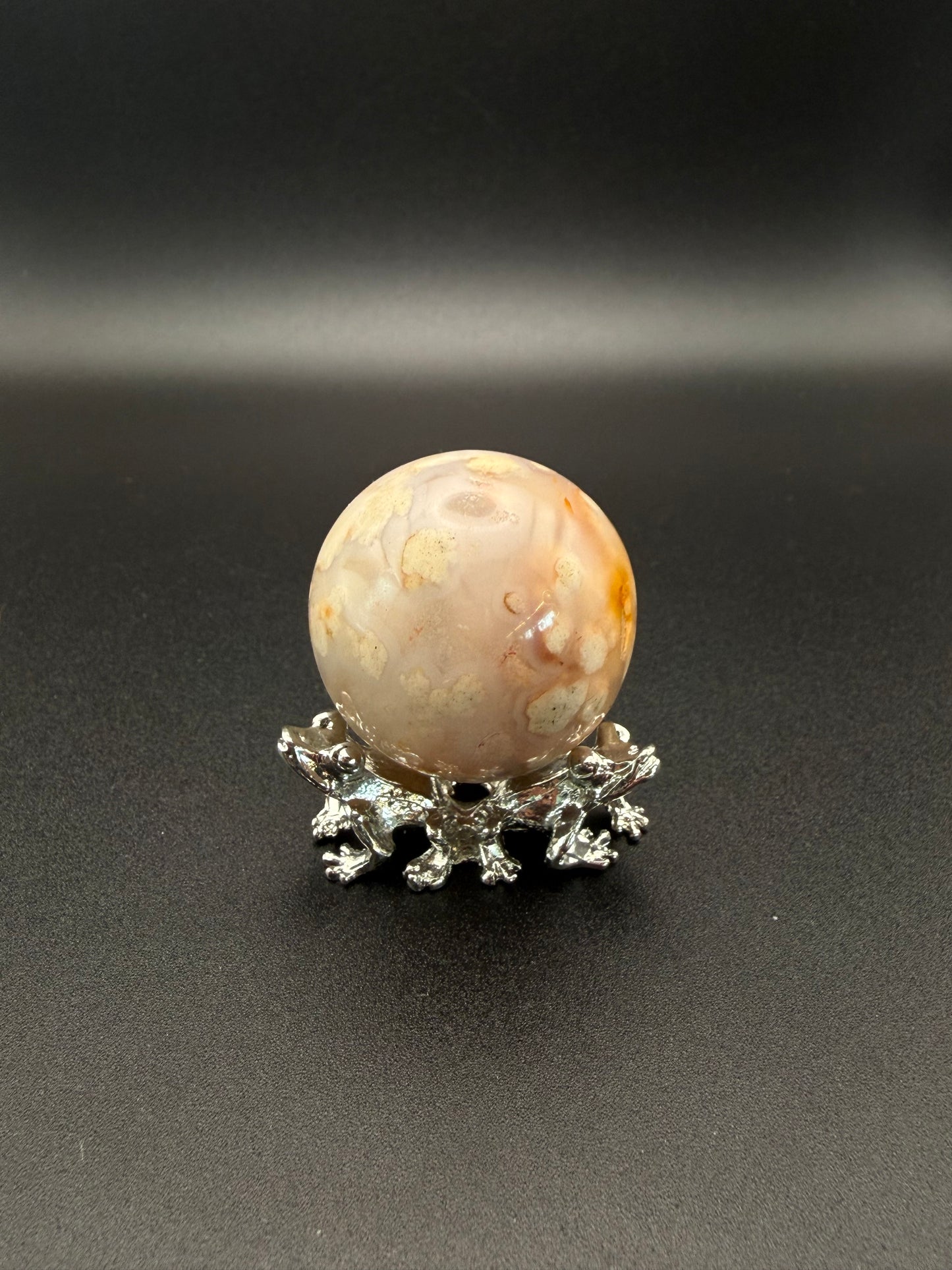 Flower agate polished crystal in the shape of a sphere.