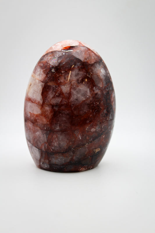 A polished red hematoid mineral specimen with a smooth surface.