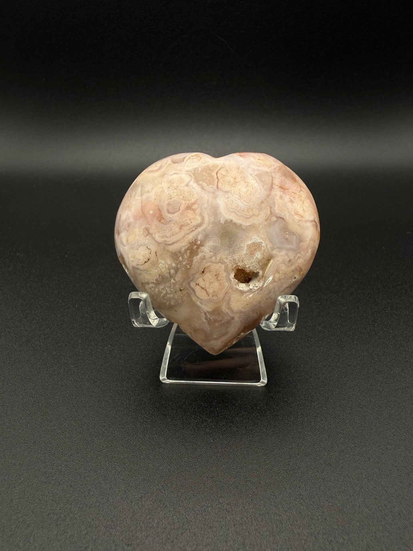 Flower agate polished crystal in the shape of a heart.