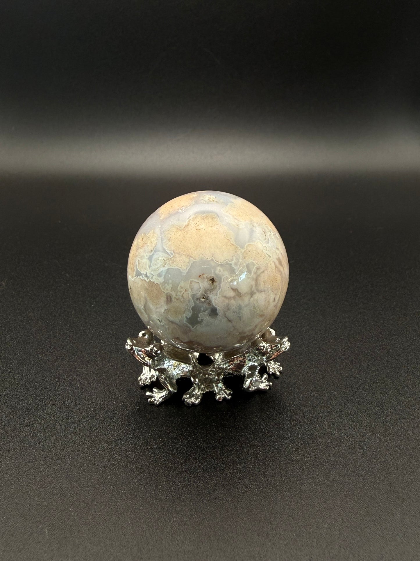 Flower agate polished crystal in the shape of a sphere.
