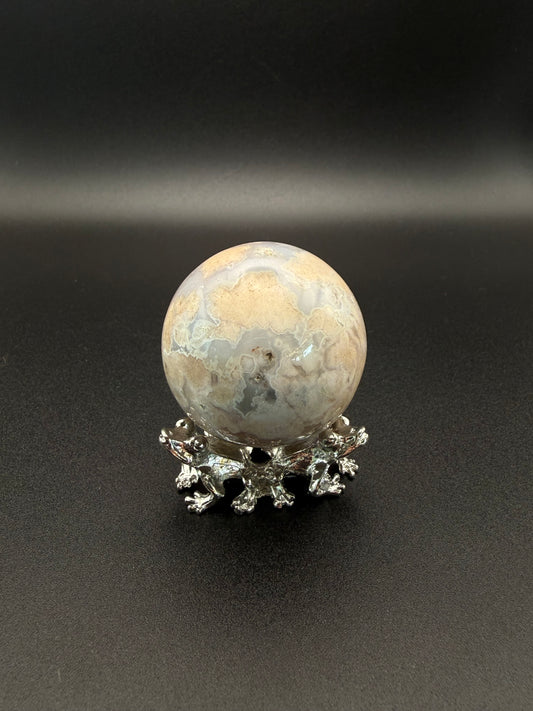 Flower agate polished crystal in the shape of a sphere.