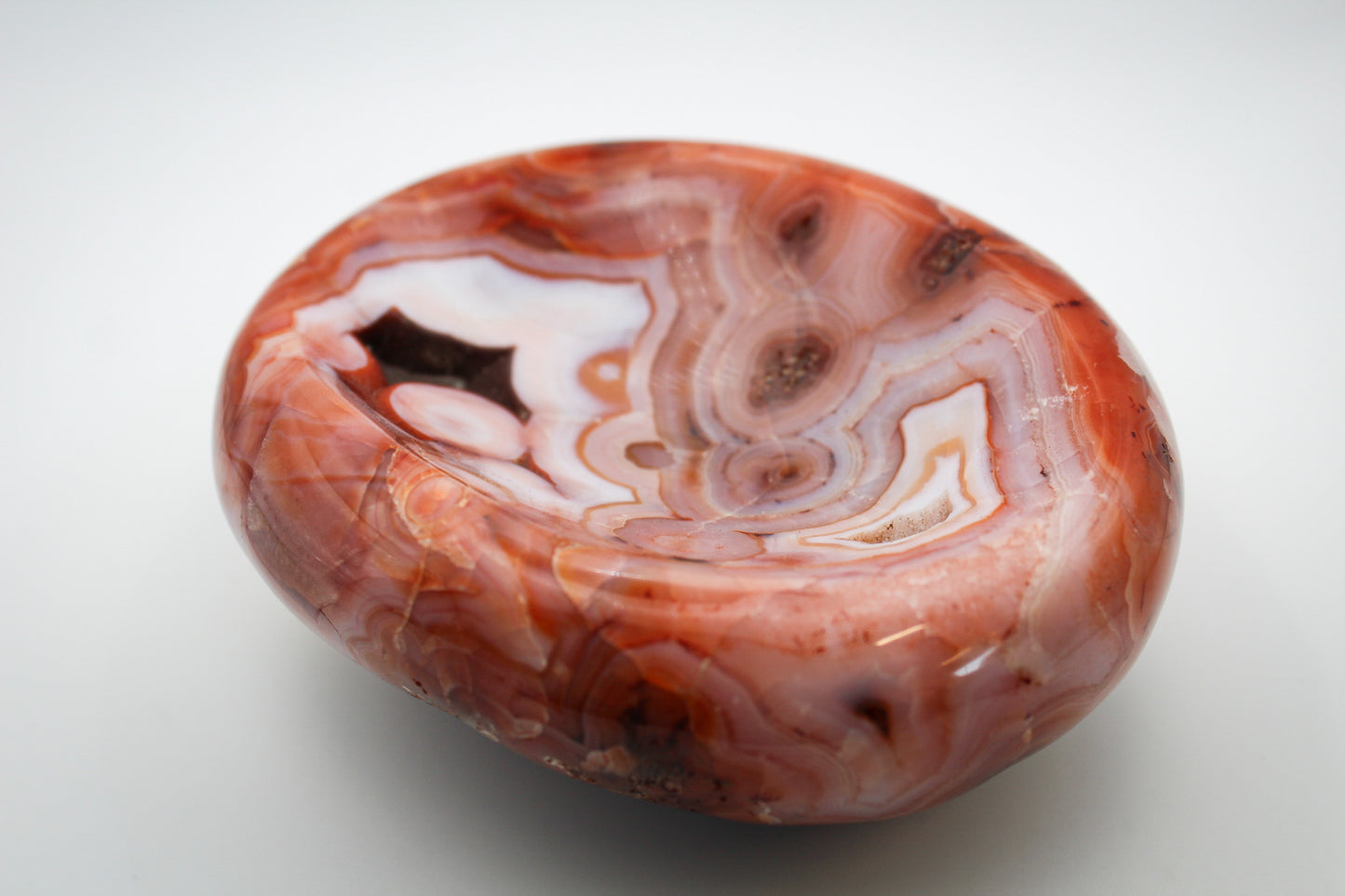 Polished carnelian crystal shaped into a bowl.
