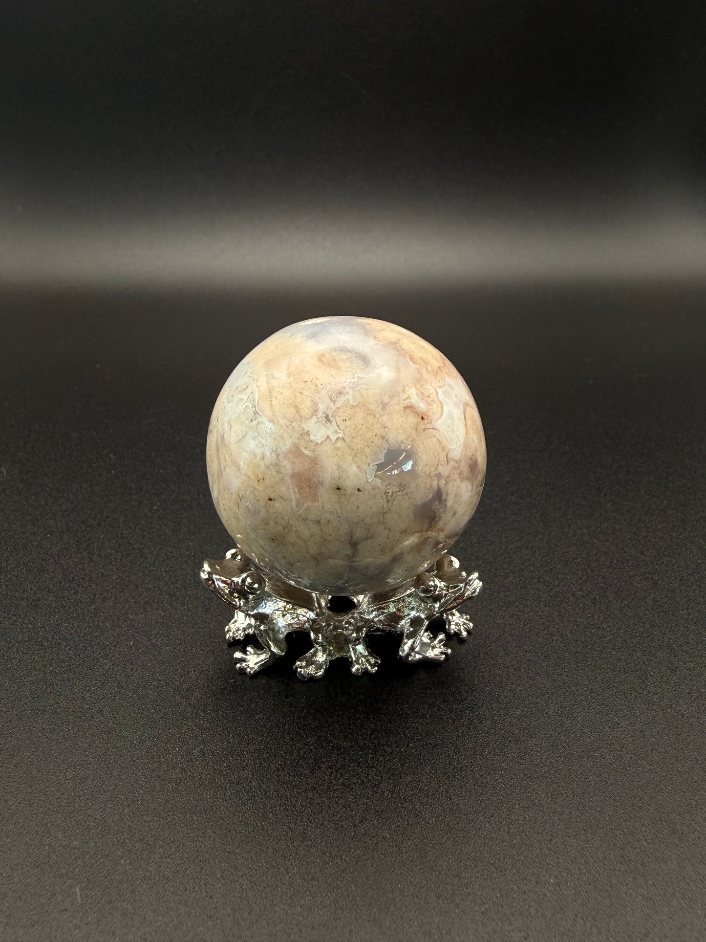 Flower agate polished crystal in the shape of a sphere.