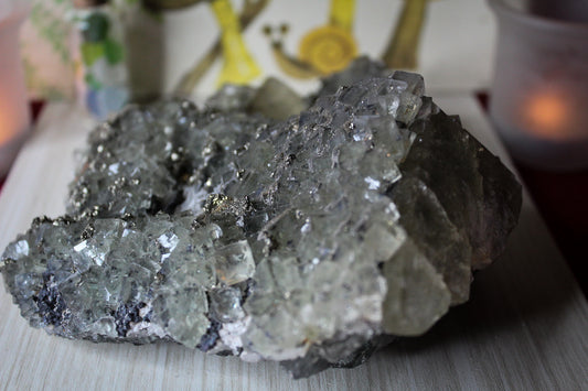 Natural fluorite crystal cluster that is green in color with pyrite inclusions.