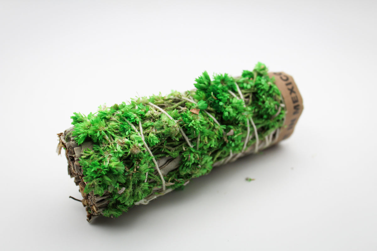 A bundle of sage with green flowers attached.
