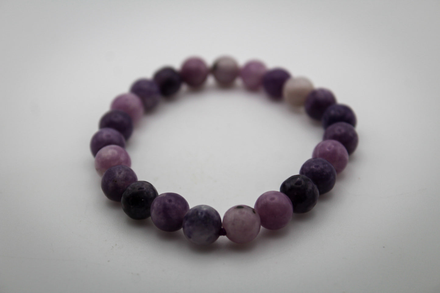 A bracelet made of purple lepidolite gemstone beads that are 8mm.