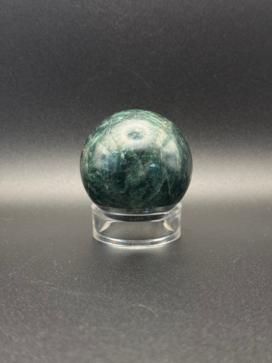 Polished green apatite crystal in the shape of a sphere.