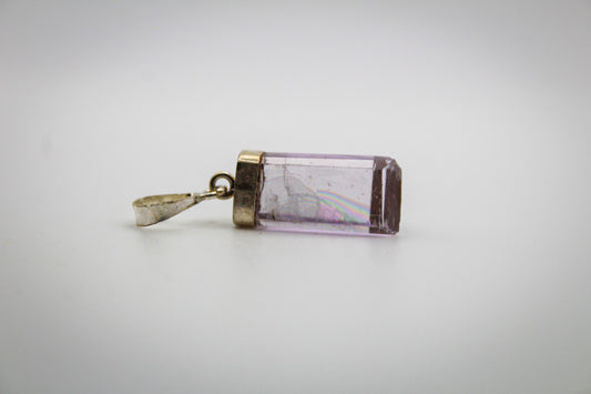 A purple Kunzite crystal pendant with a metallic cap and chain.
