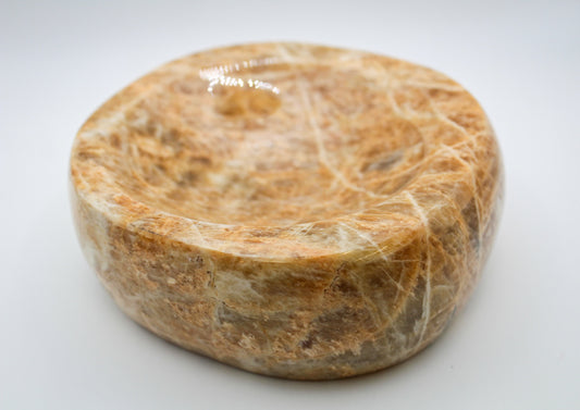 Polished yellow moonstone in the shape of a bowl.