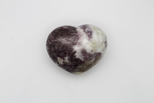 A polished heart-shaped lepidolite stone.