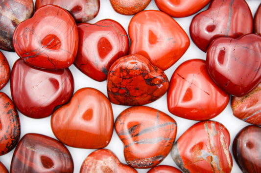 A collection of red jasper hearts of various shades and patterns.