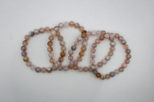 A bracelet made of polished flower agate beads with a smooth finish, showcasing a variety of natural mineral colors.
