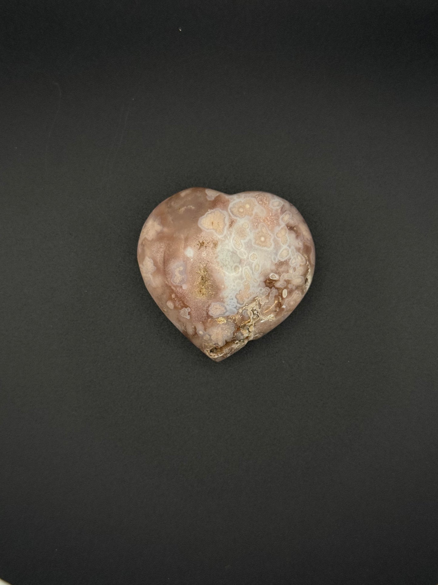 Flower agate polished crystal in the shape of a heart.