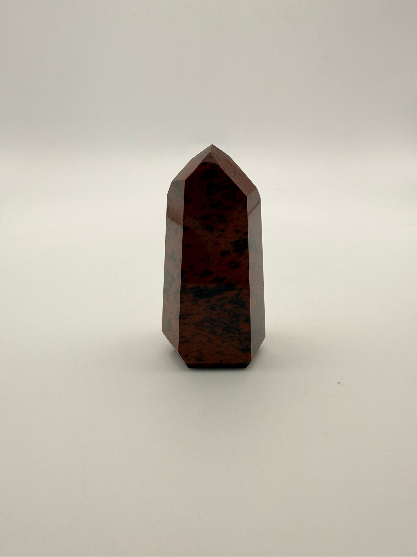 Polished mahogany obsidian tower with six sides.