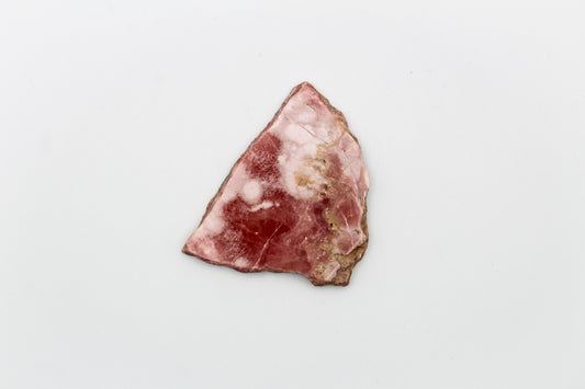 A polished rhodochrosite crystal slice.