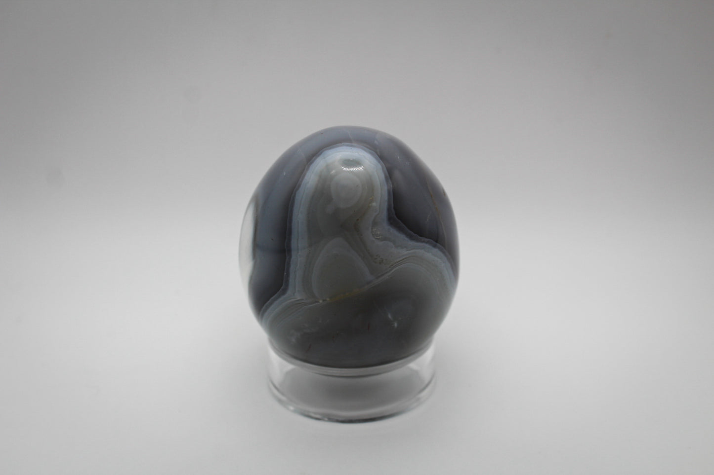An egg-shaped polished orca agate stone.