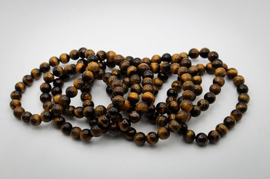 A bracelet made of yellow tiger eye stones, displayed on a plain background.