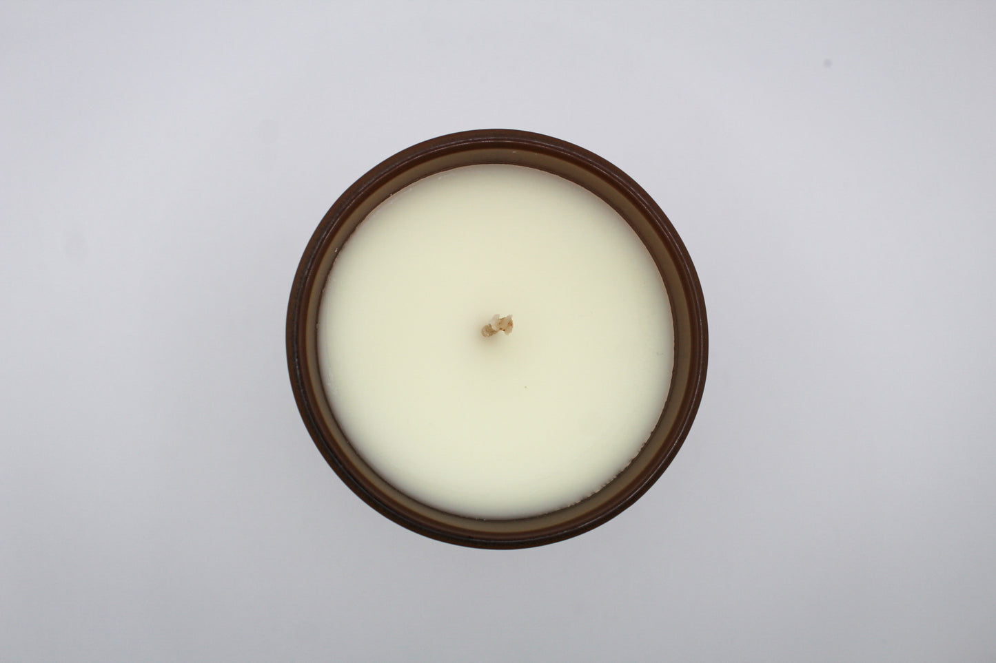 A brown candle with gold and white virgo constellation design.