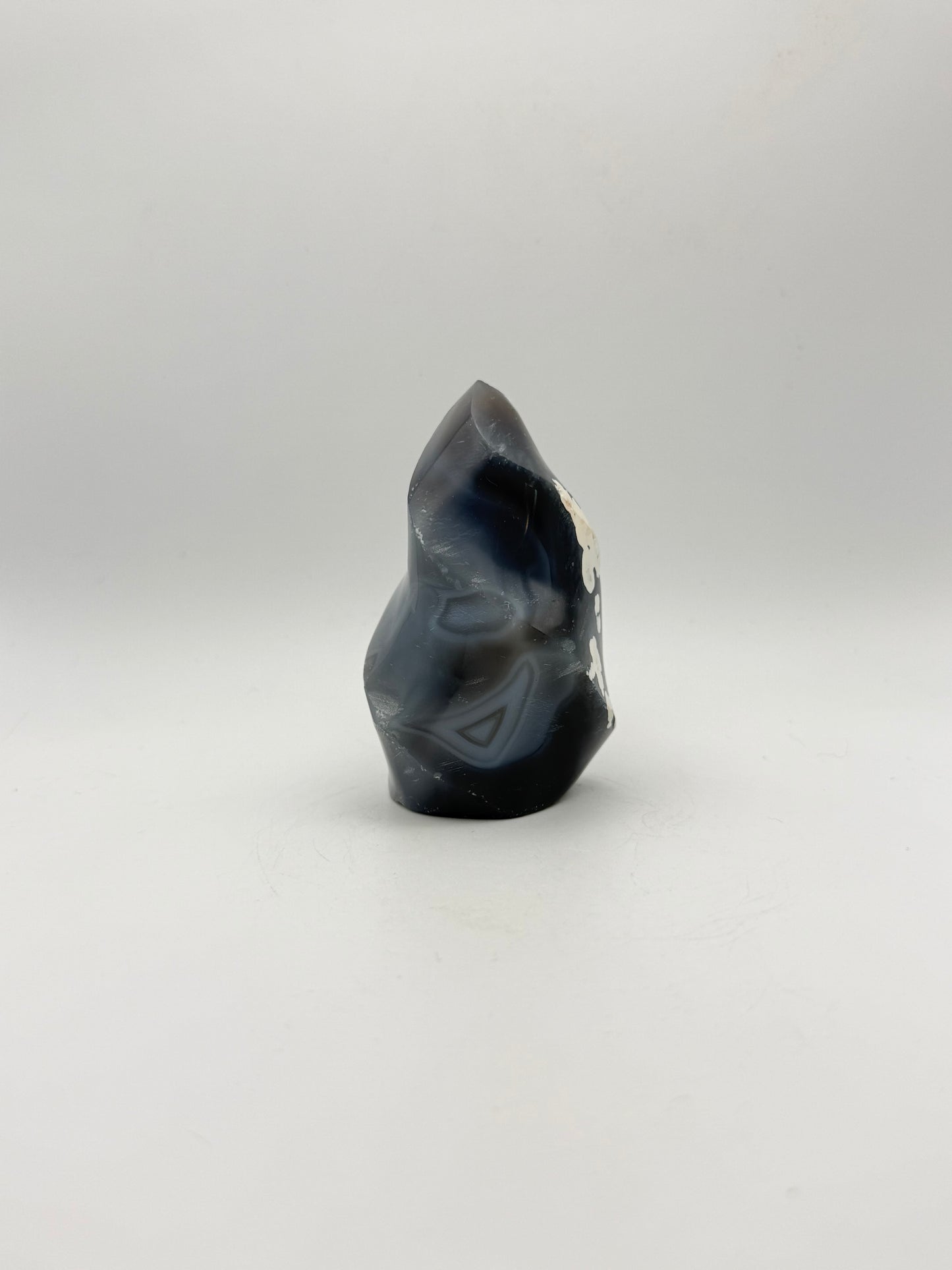 Polished orca agate in the shape of a flame.