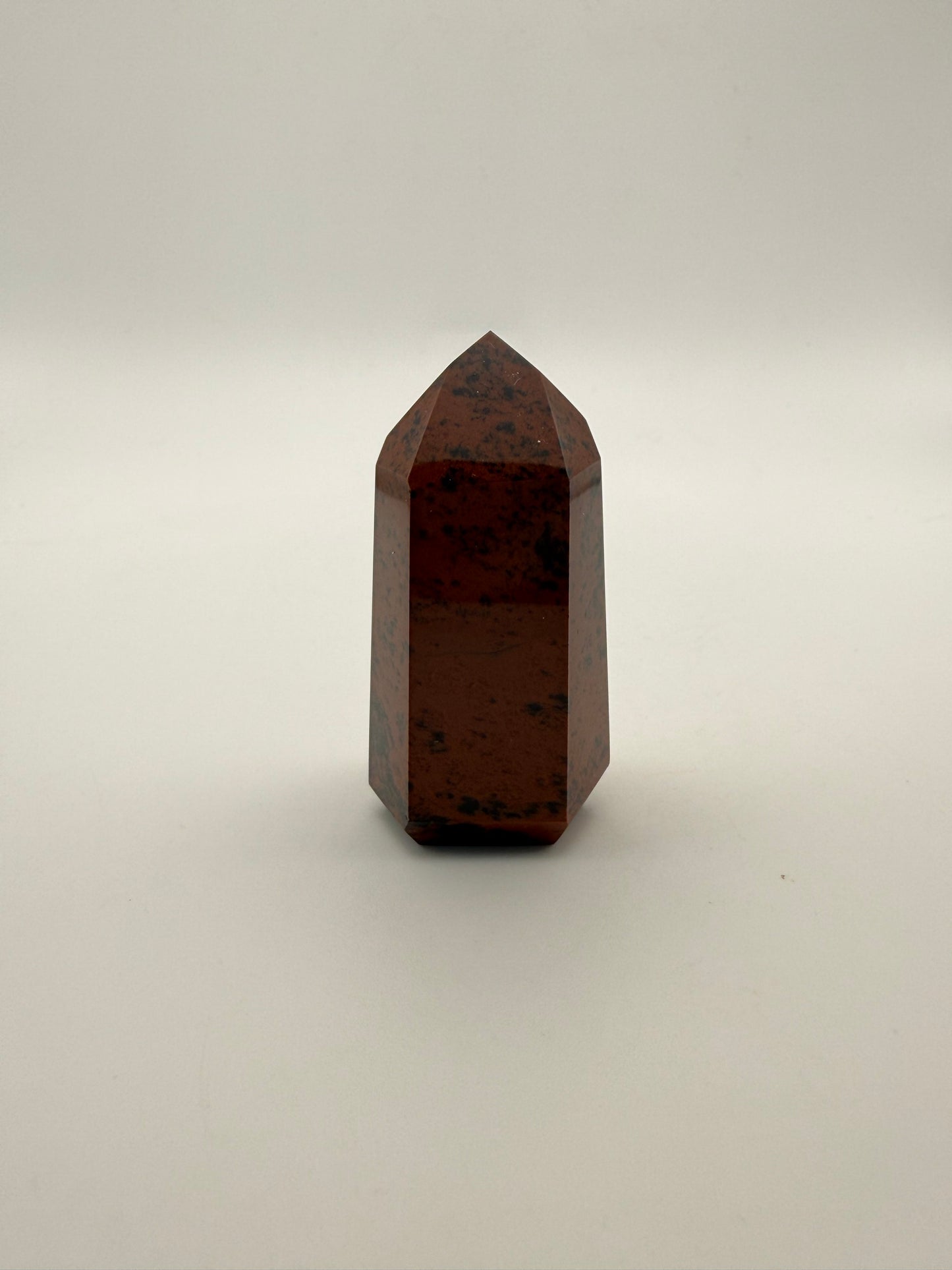 Polished mahogany obsidian tower with six sides.