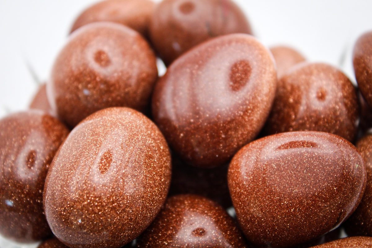 A close-up of polished goldstone tumbles.