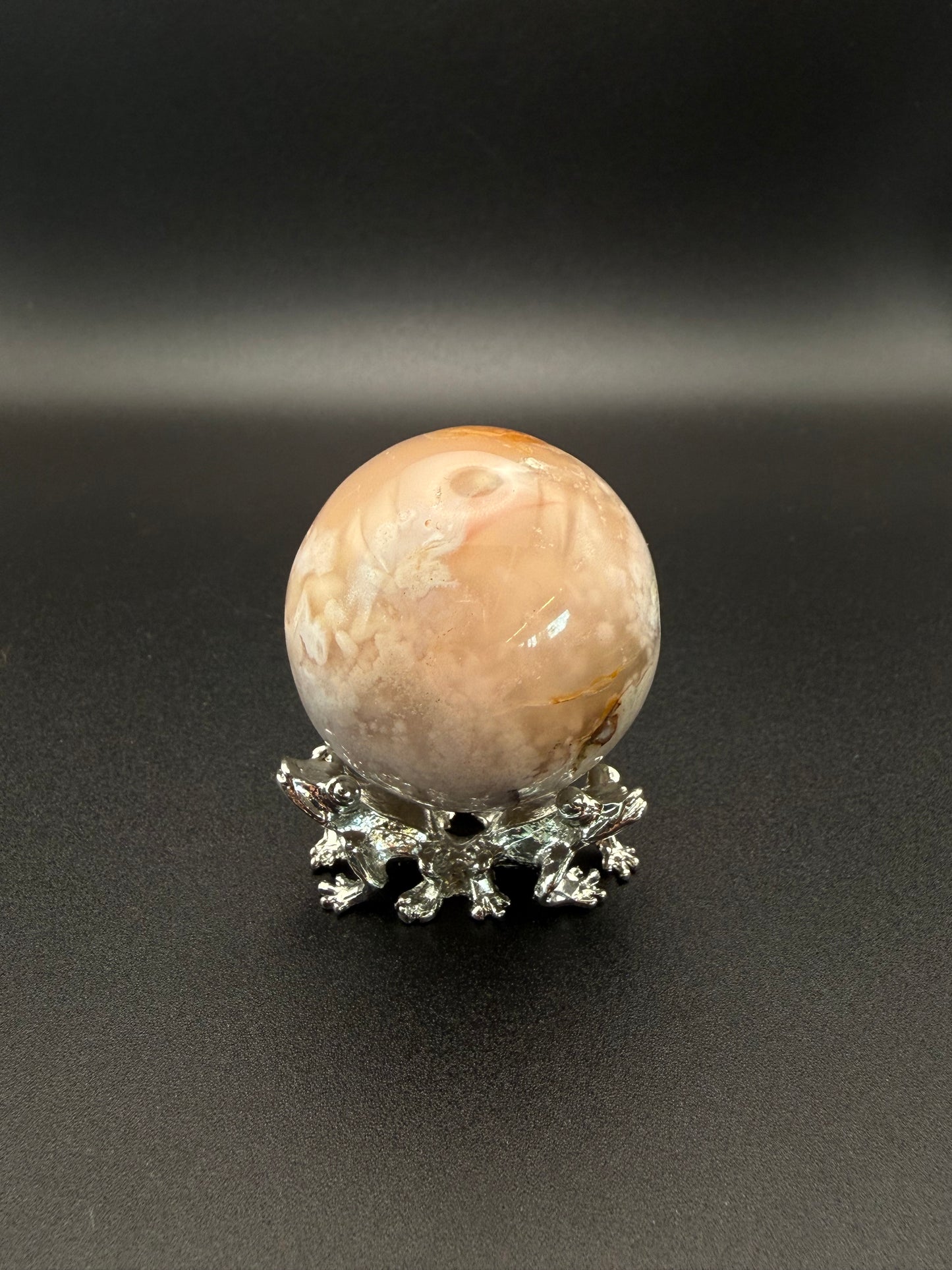 Flower agate polished crystal in the shape of a sphere.
