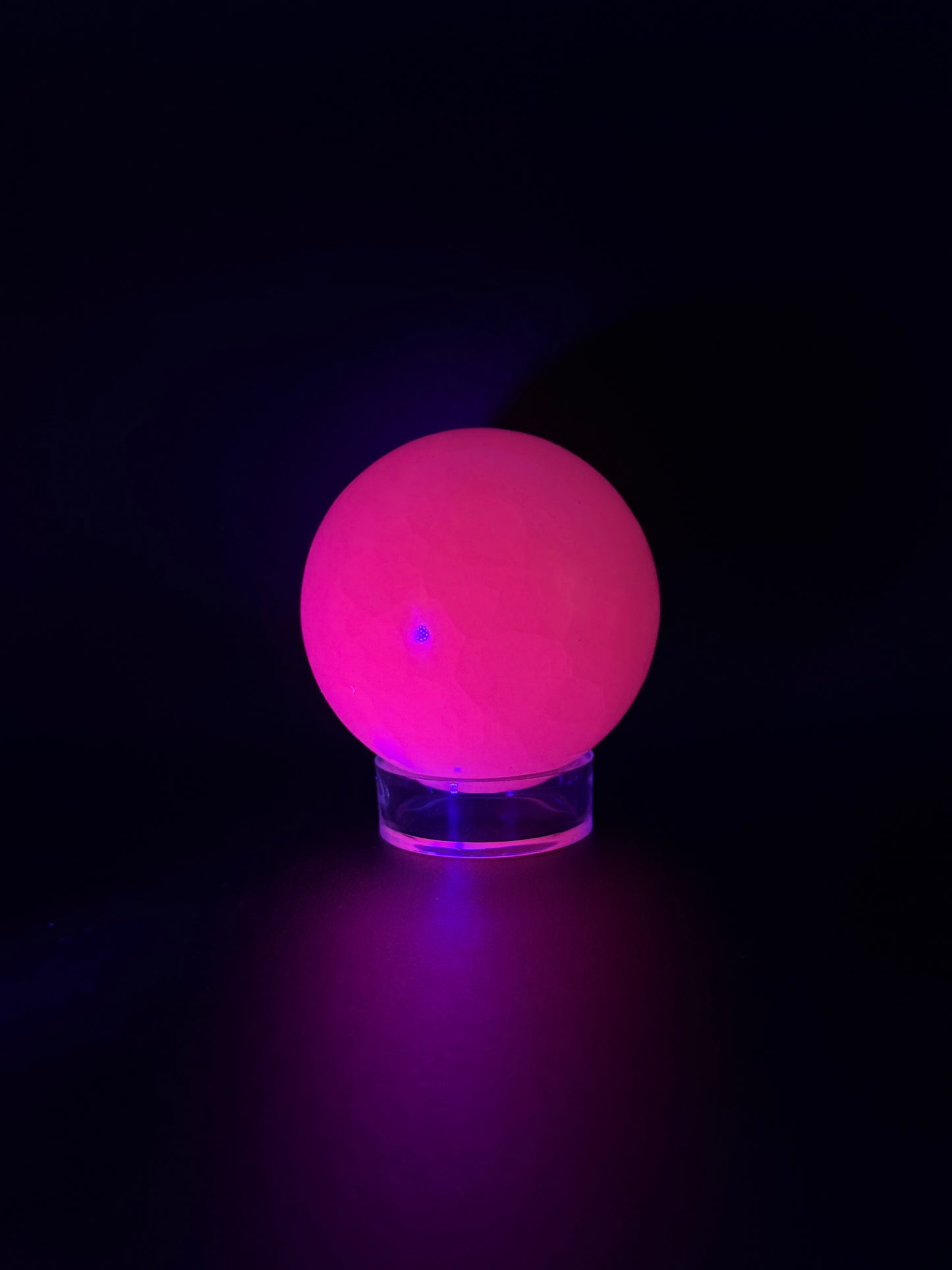 Polished pink calcite sphere. Pink calcite glows under uv light.