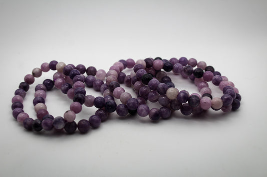 A bracelet made of purple lepidolite gemstone beads that are 8mm.