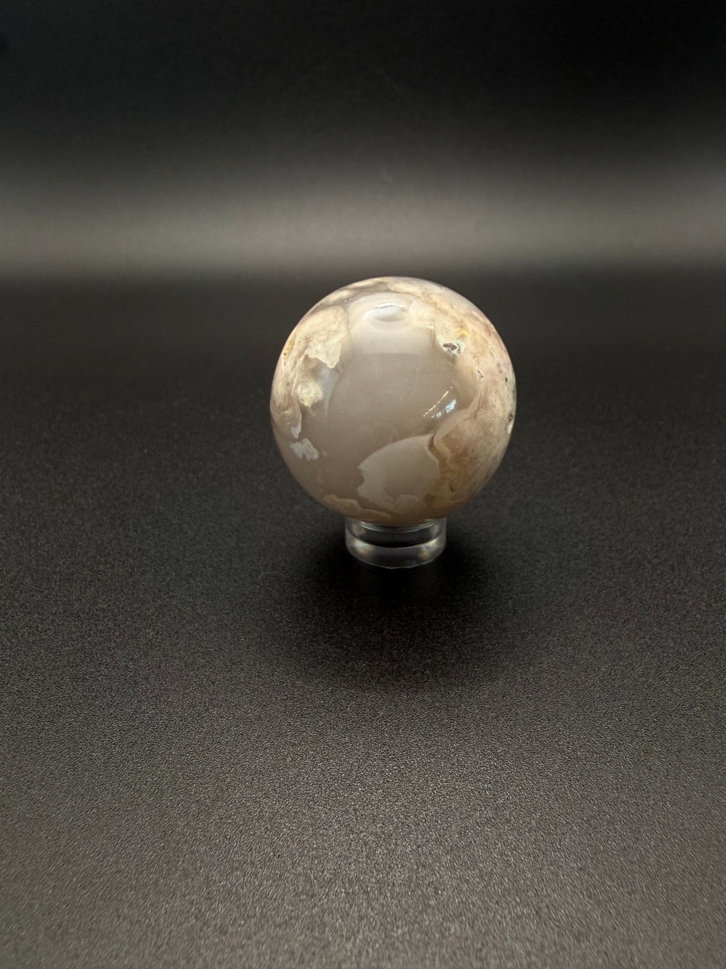 Flower agate polished crystal in the shape of a sphere.