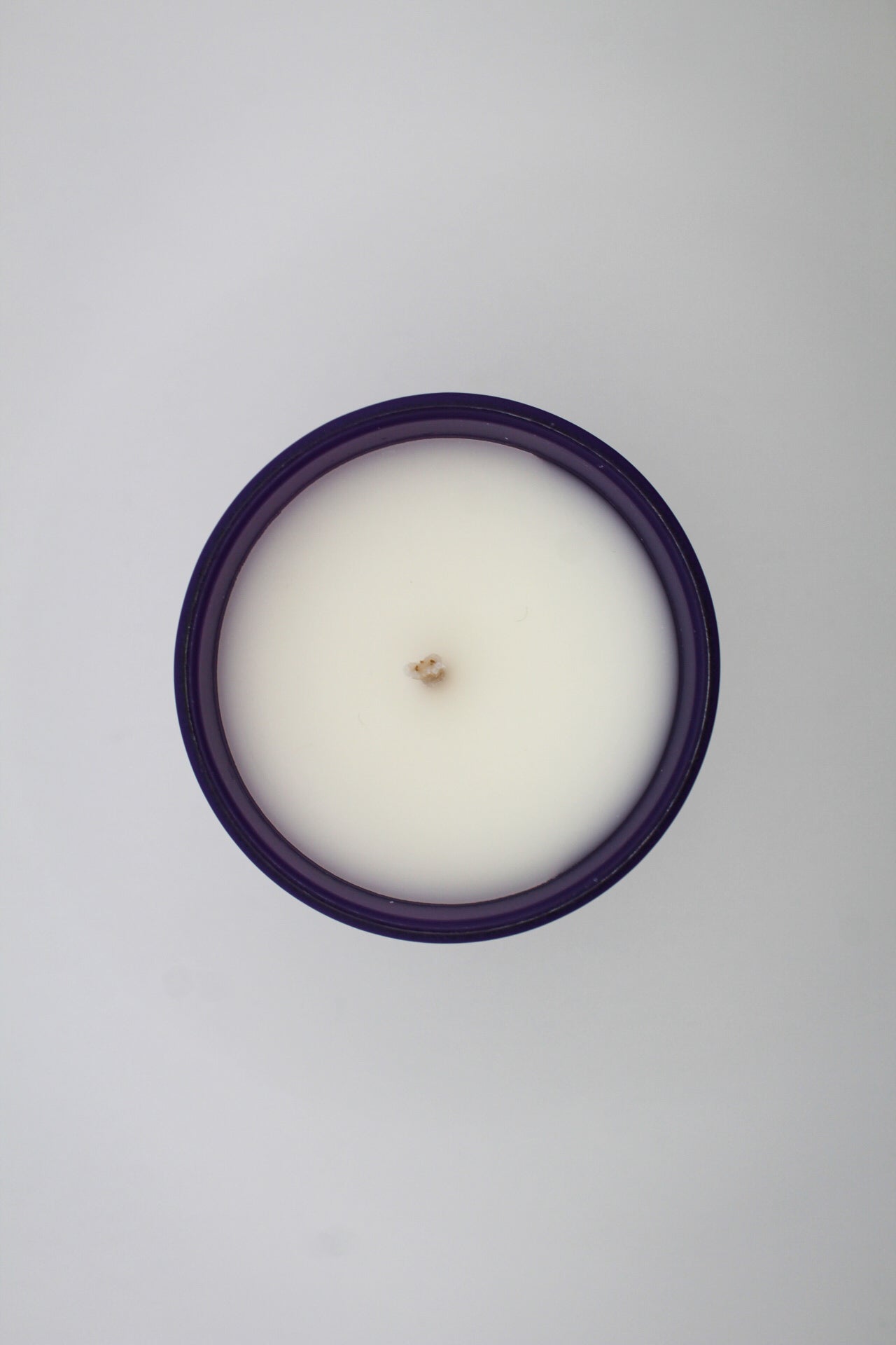 A purple candle with a Sagittarius sign design, featuring a centaur, stars, and a crescent moon.