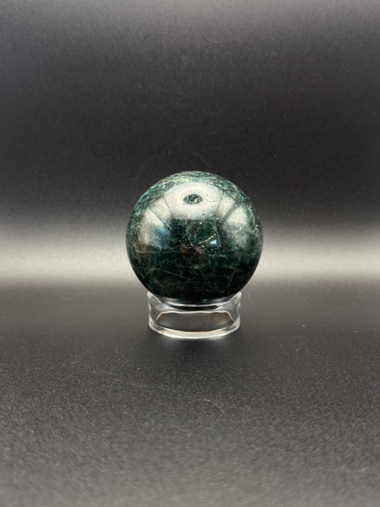 Polished green apatite crystal in the shape of a sphere.